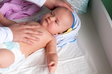 Young dad changes the diaper and clothes to his newborn small child. Selective focus.