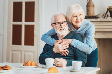Lovely aged couple having French breakfast - obrazy, fototapety, plakaty