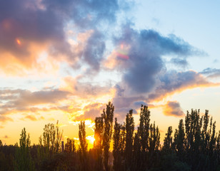Landscape with dramatic light - beautiful golden sunset with saturated sky and clouds.