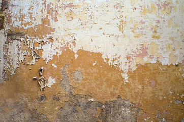 Detail of old yellow peeling walls of an abandoned space beautifully covered with colored spots, copy space.