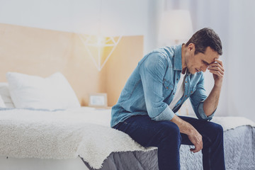 Fototapeta premium Tired man touching elbow while thinking