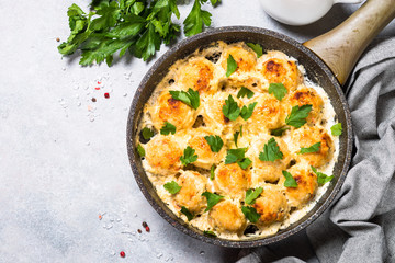 Meatballs in cream sauce with parmesan cheese top view.