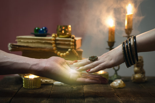 Palmistry concept. Fortune teller reading future on the hand on a magic table background. Future reading concept.