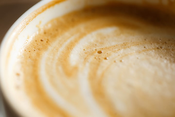  Cappuccino milk foam with bubbles in a white cup, shot on a macro lens