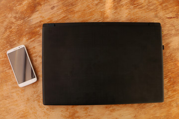 close up - computer and smart phone against wooden background