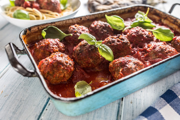 Delisious italian meal meat beef balls with pasta spaghetti and basil in vintage roaster pan