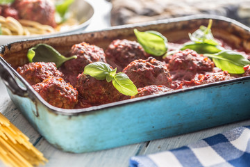Delisious italian meal meat beef balls with pasta spaghetti and basil in vintage roaster pan