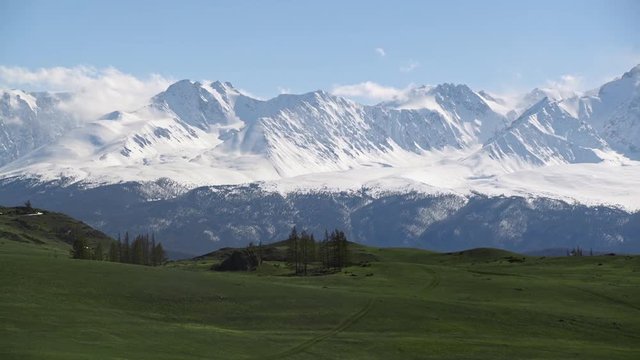 Landscape view: snow-capped altai mountain peaks with barren hills on foothills. Extreme travel to wild nature. National wildlife refuge. Amazing mongolian highland.