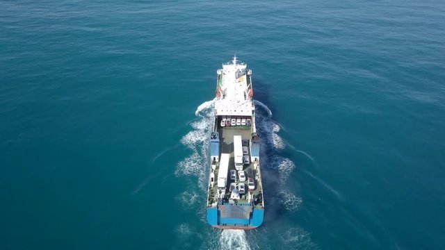 Medium sized Ro-Ro (Roll on/off) ship roaring across The Mediterranean Sea with cars and trucks seen on the upper deck.