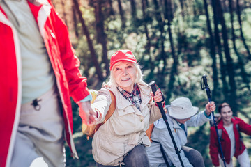 Beautiful retired woman wearing red cap holding hand of husband