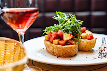 Traditional italian bruschetta with cherry tomatoes, cream cheese, peppers, arugula leaves and balsamic vinegar