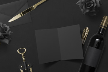 blank invitation card arranged with wine, black roses and an envelope
