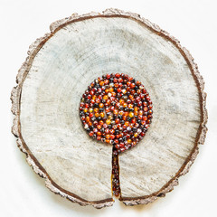 Old cross-section of a tree trunk with a crack and spiral of faceted agate beads looks like a tree....