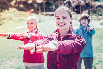 Fototapeta premium Young dark-eyed fitness trainer training retired women