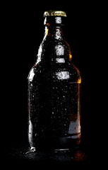Beer bottle with drops isolated on black, with clipping path 