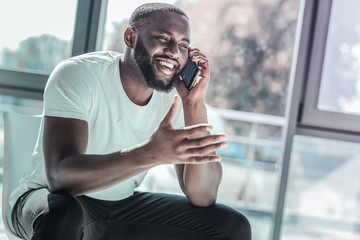 Positive delighted man talking per telephone