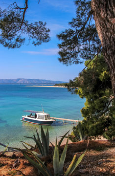 boat in front of famous beach coastline golden horn on island bol, croatia