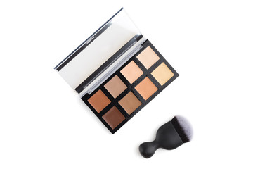 Contouring palette on a white background. Makeup palette of several colors and brush close-up.