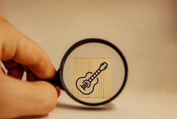 magnifying glass zooming in on guitar icon