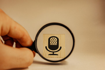 magnifying glass zooming in on microphone icon