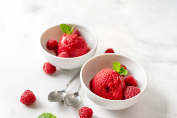 Raspberry sorbet in two cups on white table - obrazy, fototapety, plakaty
