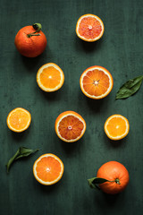 Ripe citrus fruits. Juicy oranges on green background top view.