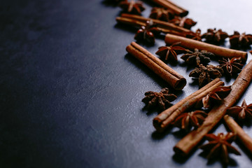 Spices sticks cinnamon and star anise on the old table. Rustic dark background, aroma close-up, macro.