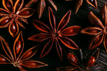 Spices of star anise on the old table. Rustic dark background, aroma close-up, macro.