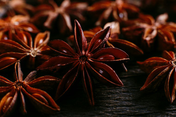 Spices of star anise on the old table. Rustic dark background, aroma close-up, macro.