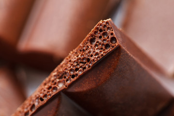 Chocolate broken into pieces. Pieces of tasty dark chocolate on white background