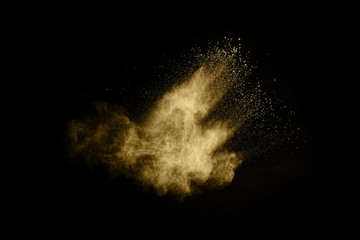 Naklejka na ściany i meble Golden powder explosion on black background. Freeze motion.