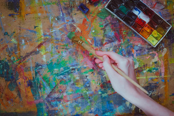 Woman hand  holding a brush and painting colorfull abstract oil picture.