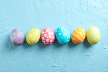 Decorative Easter eggs on color background, space for text. Top view