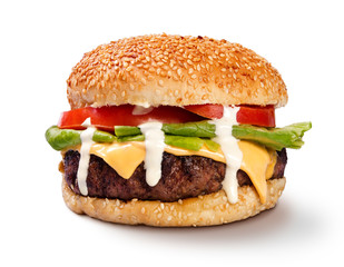 American cheeseburger with meat, cheese, lettuce, tomato and dripping white sauce  front view isolated on white studio shot