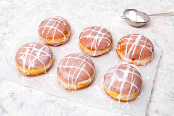 Traditional Polish donuts with white frosting on white background. Tasty doughnuts with jam.