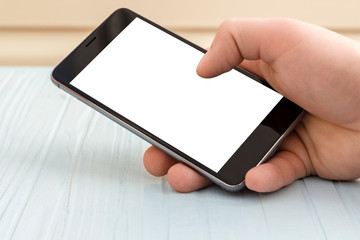 copy spaсe,   the phone is in the hand on the background of the table, white screen