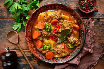 Meat stew with potato, carrot and green pea in a tomato sauce.Top view with copy space.