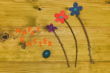 Happy Easter message with painted  eggs  and flowers on wooden table.Toned photo.