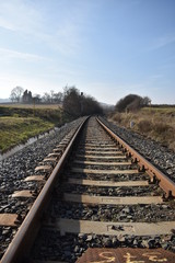 Obraz premium railway in the countryside with tepmle ruins in the background, Cikó, Hungary