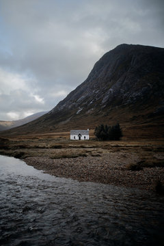 View of house by lake with mountain in background