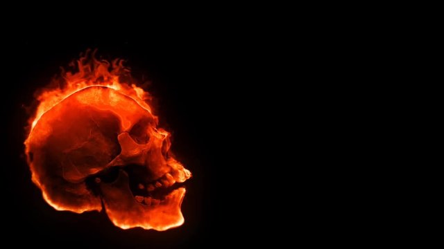 Flaming Skull with Sparks Background 4K Loop features a side profile view of a laughing flaming skull moving around with sparks rising against a black background