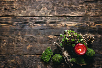 Green mossy wooden balls and dry tree branches on a brown wooden plank board background with copy...