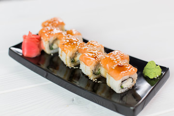 Sushi set with salmon, vasabi, ginger and sauce on black plate