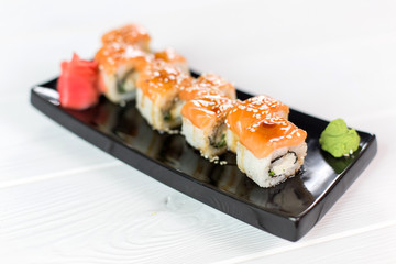 Sushi set with salmon, vasabi, ginger and sauce on black plate
