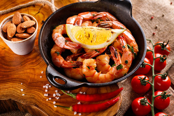 Spicy shrimp in a pan with garlic, cilantro and pepper, next ingredients for cooking, tomatoes