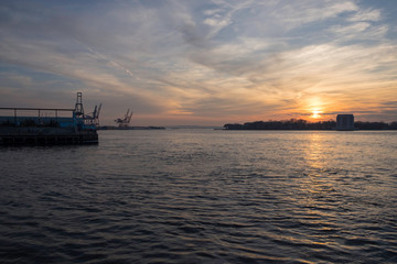 Fototapeta premium sunset over island in river with industrial machines