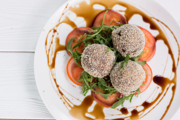 Fresh salat with tomatoes, rucola and meat rolls with sauce