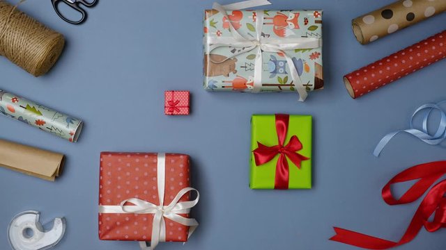 Many gifts pile on a blue background. Gift wrapping for holidays. Give or take a lot of surprise presents. Top view of festive background. Flat lay. Looped time lapse video. Endless clip stop motion.