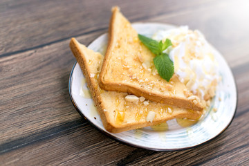 Tasty sandwich with cream, nuts and honey on wooden background