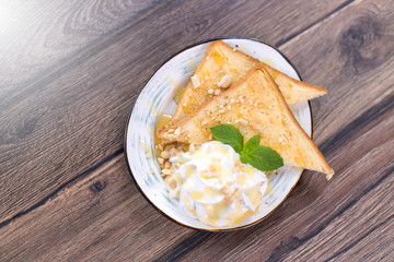 Tasty sandwich with cream, nuts and honey on wooden background